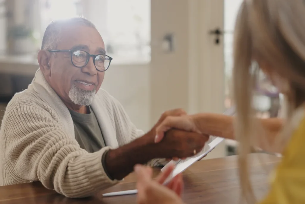 Senior man shaking woman's hand